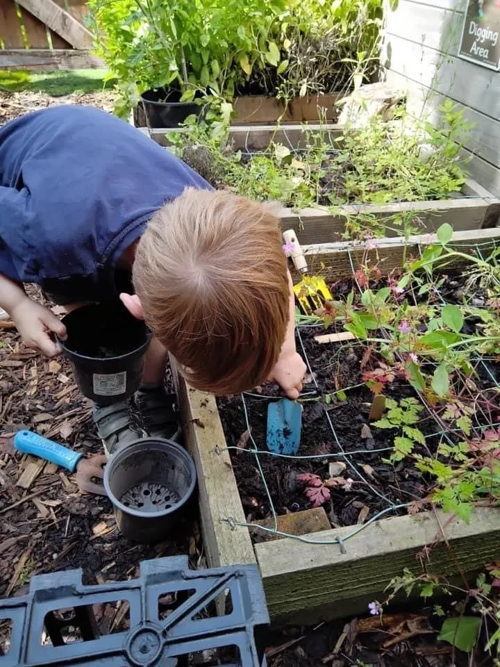 A child digging and exploring in the nursery garden