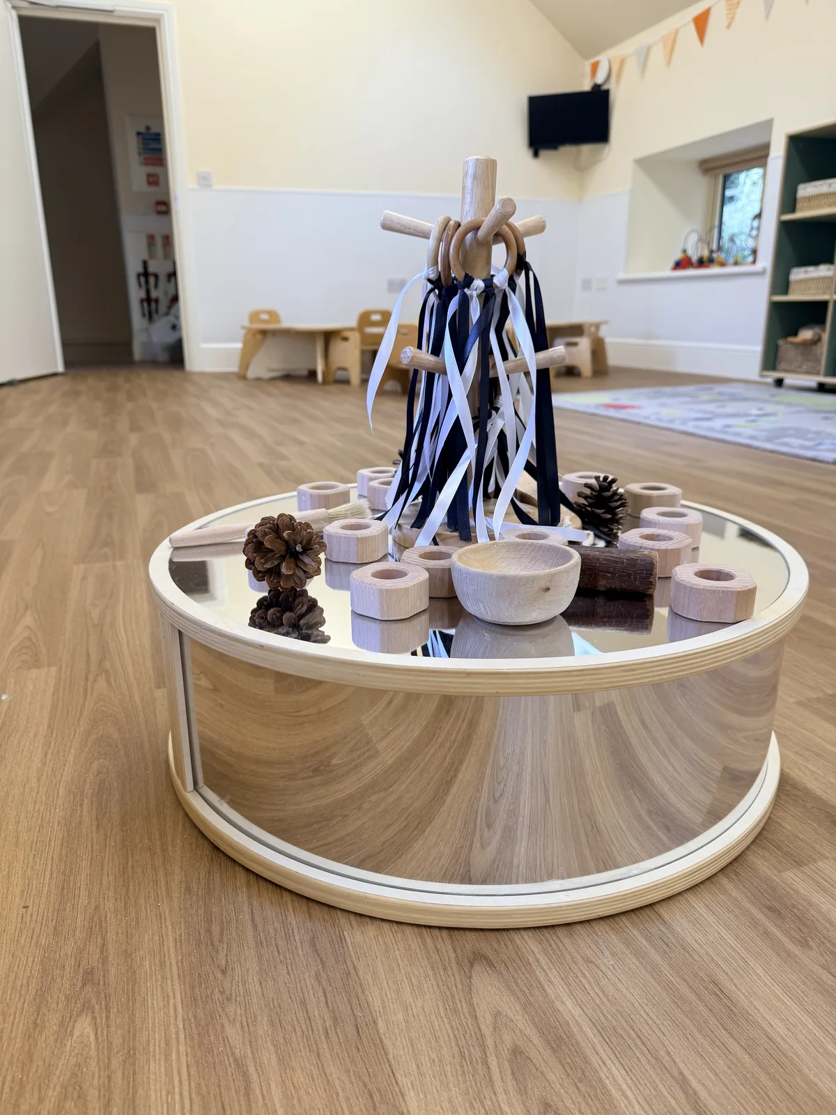 A mirrored sensory table with ribbons and natural objects at Limpley Stoke